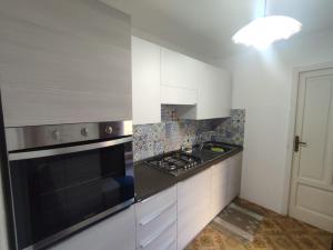 a kitchen with white cabinets and a black stove top oven at Casa Amena con ampio terrazzo e giardino in Lipari