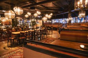 a restaurant with tables and chairs and chandeliers at Break Sokos Hotel Tahko in Tahkovuori