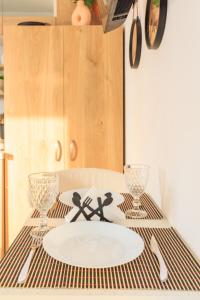 einen Tisch mit einem Teller und zwei Gläsern darauf in der Unterkunft Aiolos luxury loft new Smyrni centre in Athen
