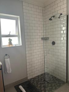 a bathroom with a shower with a glass door at Prospect Road Cottage in Walmer