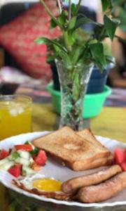 ein Frühstücksteller mit Wurst und Toast in der Unterkunft Laskus , Darjeeling in Darjeeling