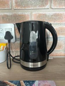 a black tea kettle sitting on a table at Prospect Cottage in Walmer