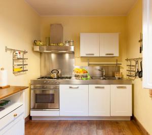 a kitchen with white cabinets and a stainless steel stove at Appartamento Girasole in Capannori
