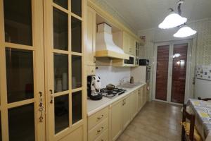 a kitchen with wooden cabinets and a stove top oven at Vesuvio Guest House in Ercolano