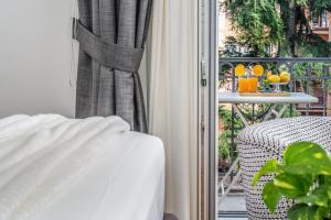 a bed and a chair in a room with a balcony at Tavernola35 - Luxury apartment in Castellammare di Stabia