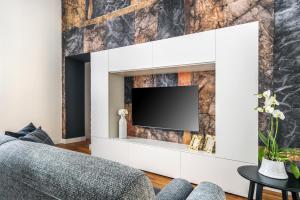 a living room with a tv on a wall at Tavernola35 - Luxury apartment in Castellammare di Stabia