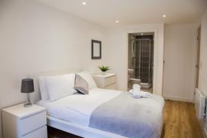 um quarto branco com uma cama branca e uma janela em Luxury 2 Bed Apartment em Manchester