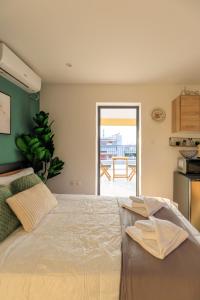 um quarto com uma cama grande e uma porta para um pátio em Aiolos luxury loft new Smyrni centre em Atenas