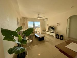 un salon avec une plante au milieu dans l'établissement Apartment with Sea and views near Marbella Spain, à Cabopino