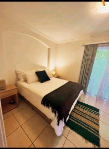 Un dormitorio con una cama grande y una ventana en OakTree Guest House en Sandton
