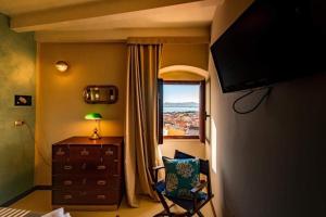 サンタンティーオコにあるLe Tre Caravelleの窓、デスク、椅子が備わるベッドルーム1室が備わります。
