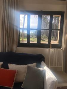 a room with two windows and a couch with pillows at Studio de l'oliveraie in Aix-en-Provence