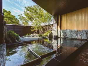 duży basen z wodą w ogrodzie w obiekcie Etajimasou w mieście Etajima