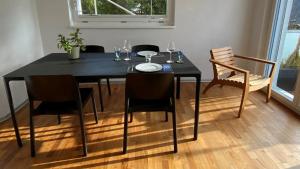 een eettafel met stoelen en een zwarte tafel bij Ferienwohnung Chasa Splerin mit Whirlpool auf Terrasse in Scuol