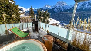 a hot tub on a balcony with snow covered mountains at Ferienwohnung Chasa Splerin mit Whirlpool auf Terrasse in Scuol