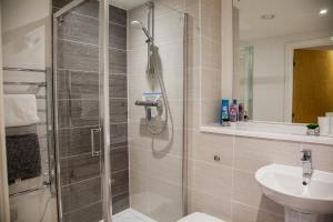 uma casa de banho com um chuveiro e um lavatório. em Luxury 2 Bed Apartment em Manchester