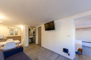 a living room with a couch and a tv on a wall at Castelli's Apartmetnts FICO 1 in Genova