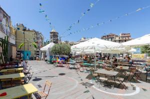 an outdoor patio with tables and chairs and umbrellas at Castelli's Apartmetnts FICO 1 in Genova