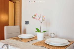 einen Tisch mit zwei Platten und eine Vase mit Blumen in der Unterkunft Il Nido delle Cinque Terre in Volastra