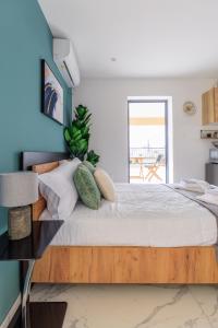 ein Schlafzimmer mit einem großen Bett mit blauer Wand in der Unterkunft Aiolos luxury loft new Smyrni centre in Athen