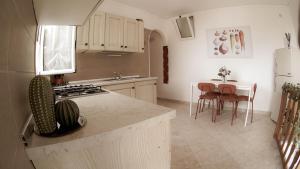 a kitchen with a stove and a table with chairs at Casa nel borgo dei gatti in Cetara