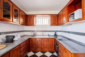 uma cozinha com armários de madeira e uma pia em Dream Paradise em Água de Pena mais 13 fotografias