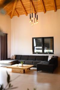 a living room with a black couch and a table at Vikendica Krcmarice- Banja Luka in Banja Luka
