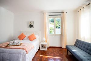 um quarto com uma cama, um sofá e uma janela em Dream Paradise em Água de Pena