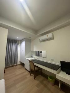 um quarto com uma secretária e uma cozinha com uma janela em Royal Garden Home Hotel em Banguecoque