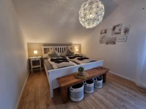 una camera con letto, tavolo e lampadario a braccio di Andinas FeWo - Wunderschöner Ausblick auf den See a Olpe
