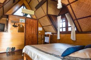 a bedroom with a large bed in a room with wooden walls at RoomQuest Golden Triangle Premium Collection in Chiang Saen