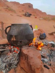a pot sitting on top of a camp fire at Couleur du désert in Mhamid
