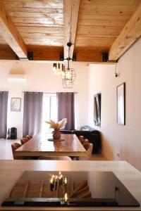 a living room with a wooden ceiling and a table at Vikendica Krcmarice- Banja Luka in Banja Luka