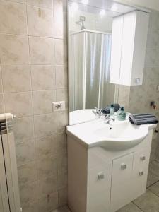 W łazience znajduje się biała umywalka i lustro. w obiekcie Casa Milano, Como, Varese w mieście Cislago