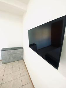 TV de pantalla plana colgada en la pared en Casa Milano, Como, Varese, en Cislago