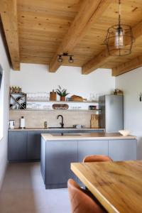 巴尼亞盧卡的住宿－Vikendica Krcmarice- Banja Luka，厨房设有木制天花板和木桌