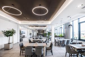 a restaurant with tables and chairs and windows at Otto Hotel-Restaurant in Rivne