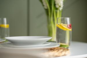 een glas water met een stuk fruit en een bord bij Wallington House By Horizon Stays in Stockton-on-Tees