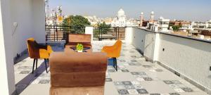 einen Balkon mit Stühlen und einem Tisch sowie Stadtblick in der Unterkunft Hotel Heaven View - 50m From Golden Temple in Amritsar