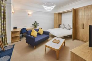 a hotel room with a bed and a blue couch at Host & Stay - Thamesview in Staines