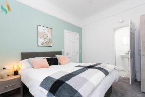 a bedroom with a large bed with pink and black pillows at 5 Double Bedrooms with Ensuites - Teesside House TSAC in Redcar