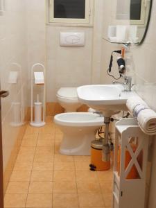 a bathroom with a white toilet and a sink at Cocciu D’amuri in Palermo