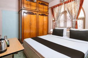 een slaapkamer met een groot bed en een raam bij OYO Brothers Inn in kolkata