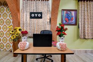 een tafel met twee vazen en een laptop erop bij OYO Brothers Inn in kolkata