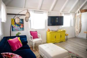 a living room with a blue couch and a yellow cabinet at The Royal Wait - An Elegant Retreat in Christiansted