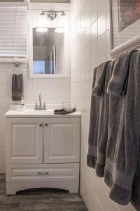 uma casa de banho branca com um lavatório e um espelho em Blackbeards Rendezvous Downtown Danish Villa em Christiansted
