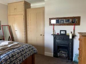 a bedroom with a bed and a black fireplace at St Elmo Felixstowe in Felixstowe