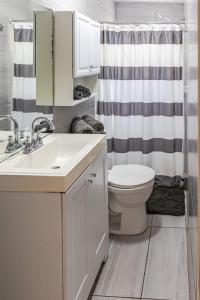 een badkamer met een wastafel, een toilet en een douche bij The Roosters Perch - A Quaint Island Homestead in Christiansted