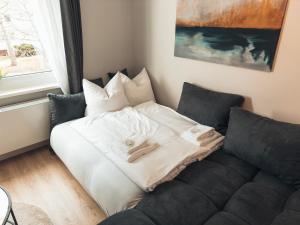una cama con almohadas junto a un sofá en RR - NEW - Gorgeous 50qm Apartment - Washer - WIFI, en Rusches Hof