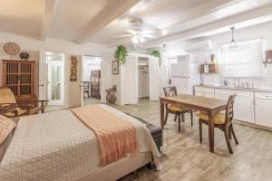 a bedroom with a bed and a table and a kitchen at Zen Treasure - A Mateys Retreat in Christiansted